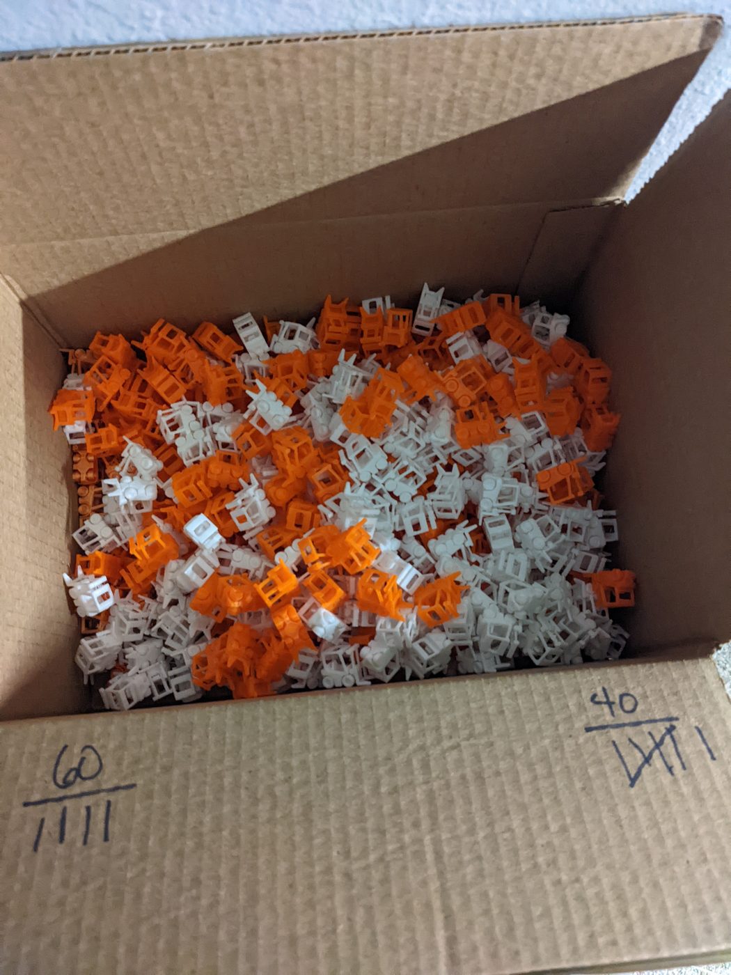 Shipping box packed with orange and white forklifts, tally counts on the flap