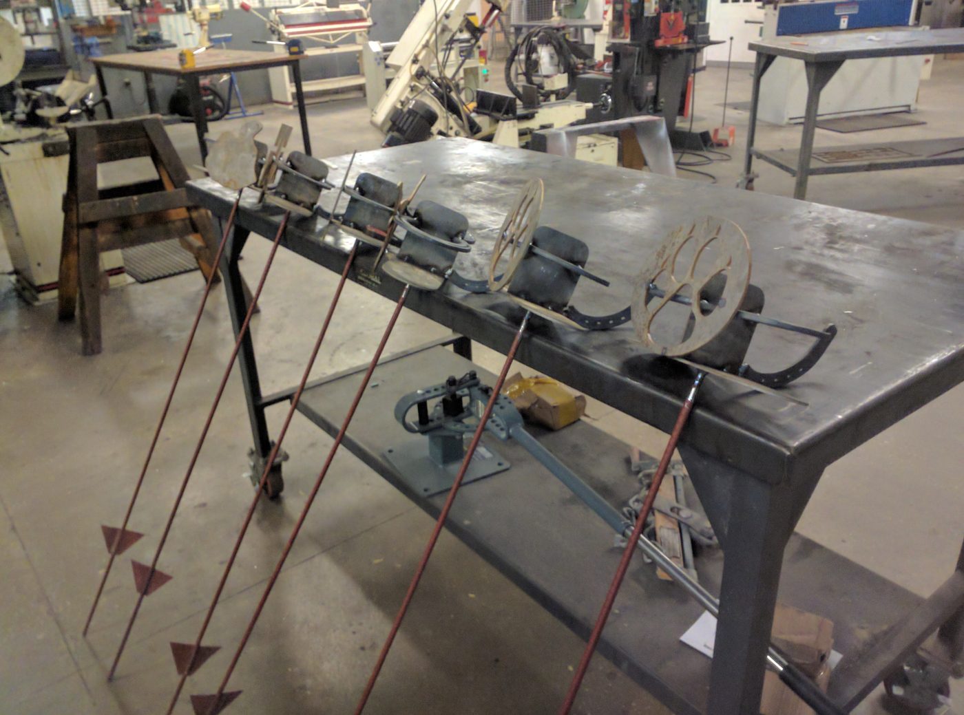 Metal pieces in progress on a steel table